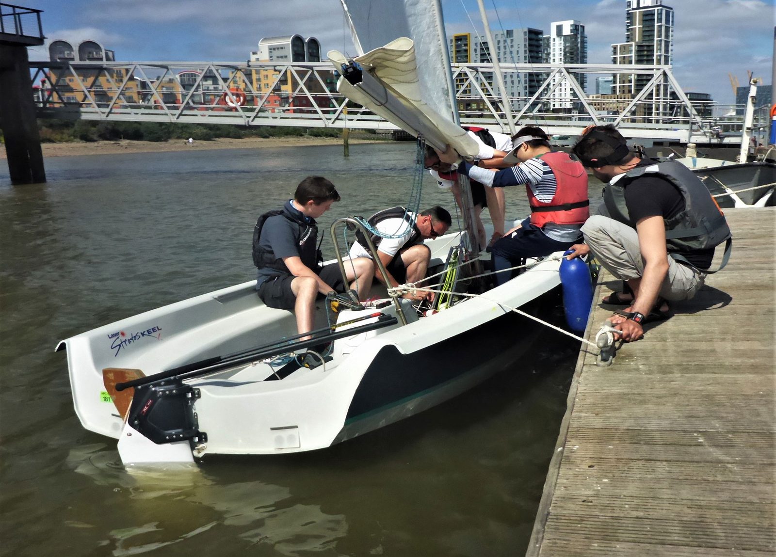An instructor and trainees in a RIB and a dinghy alongside the pontoon during a training session